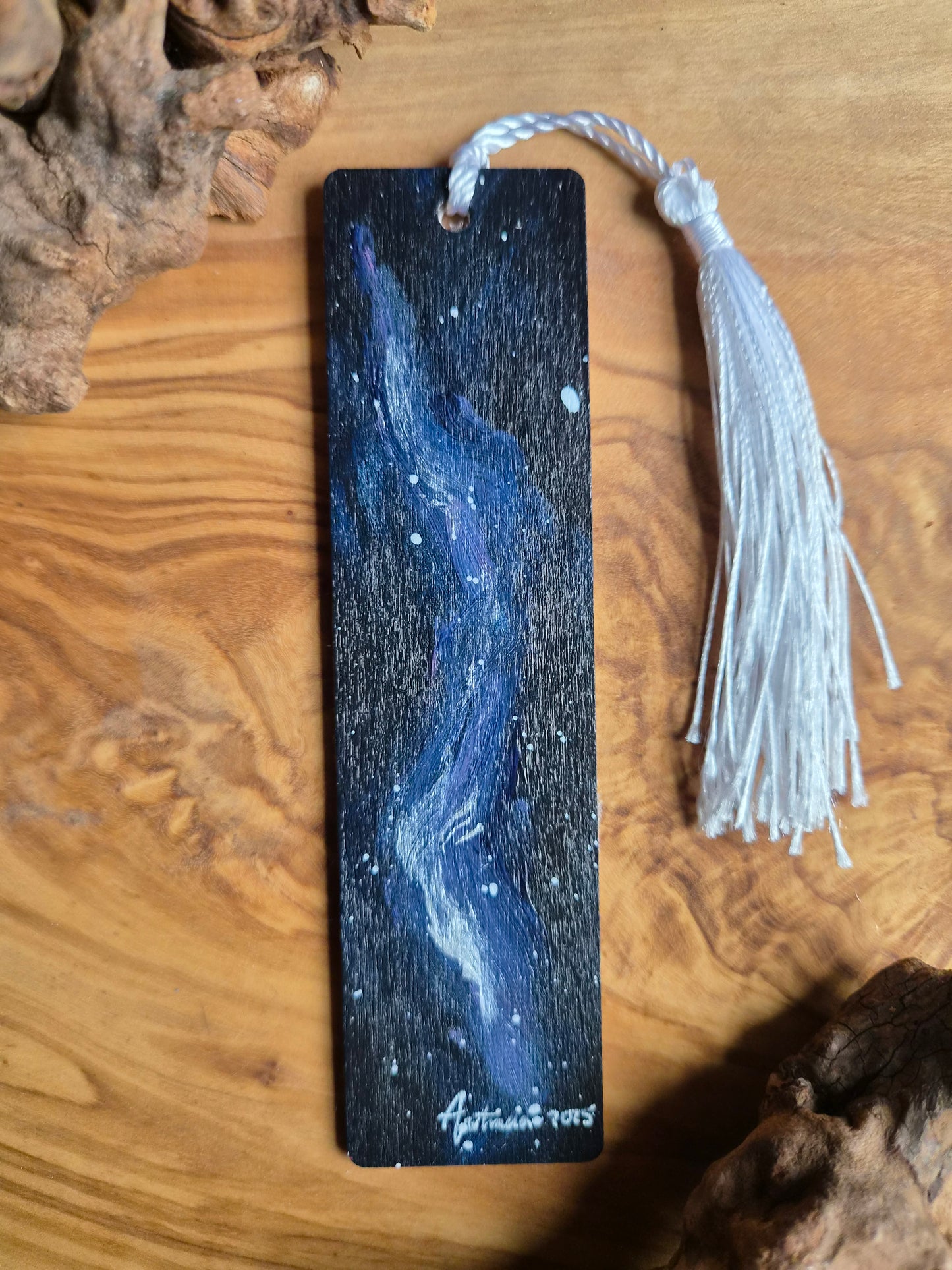Hand-painted wooden bookmark ofblue and silver galaxy design