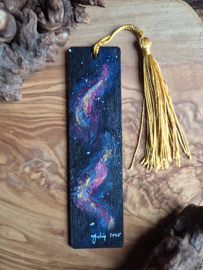 Hand-painted wooden bookmark of a pink and gold sparkly galaxy