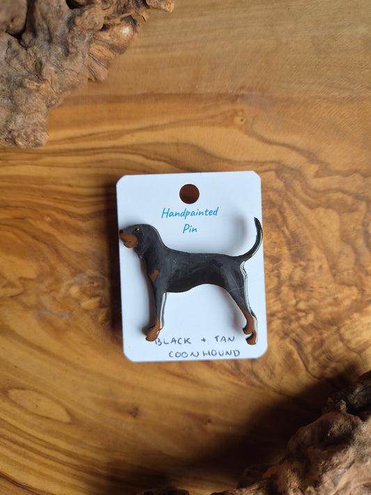 Hand-painted wooden dog shaped pin badge of a black and tan coonhound