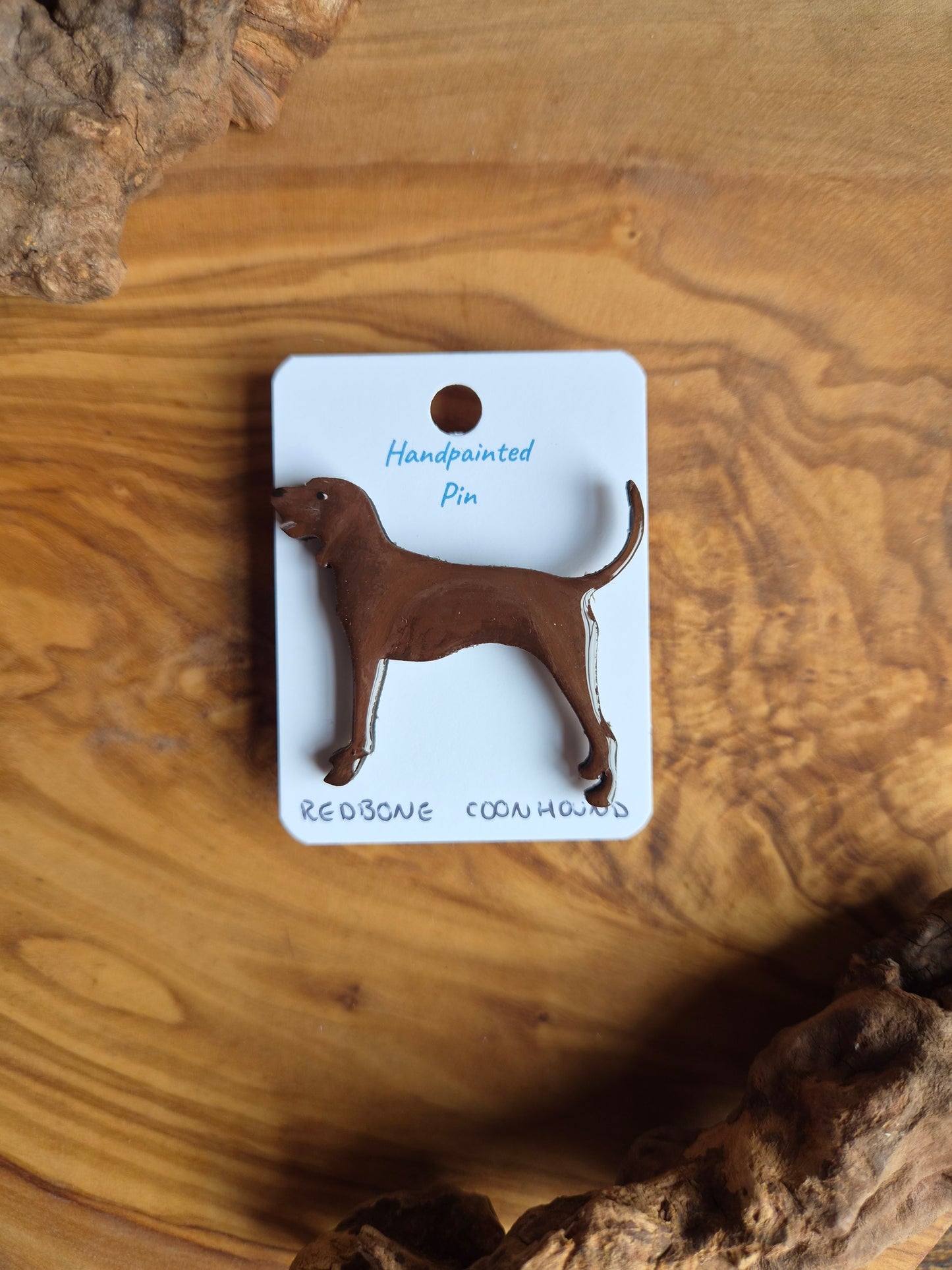 Hand-painted wooden dog shaped pin badge of a brown redbone coonhound