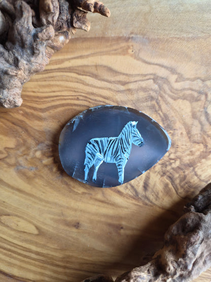 a small hand-painted natural agate slice with a painting of a zebra on it