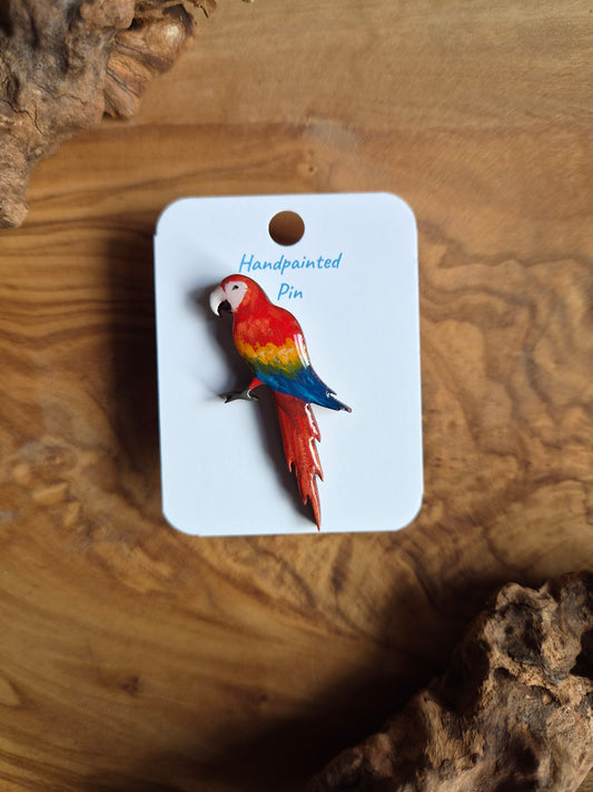 Hand-painted wooden parrot shaped pin badge of the colourful scarlet macaw 