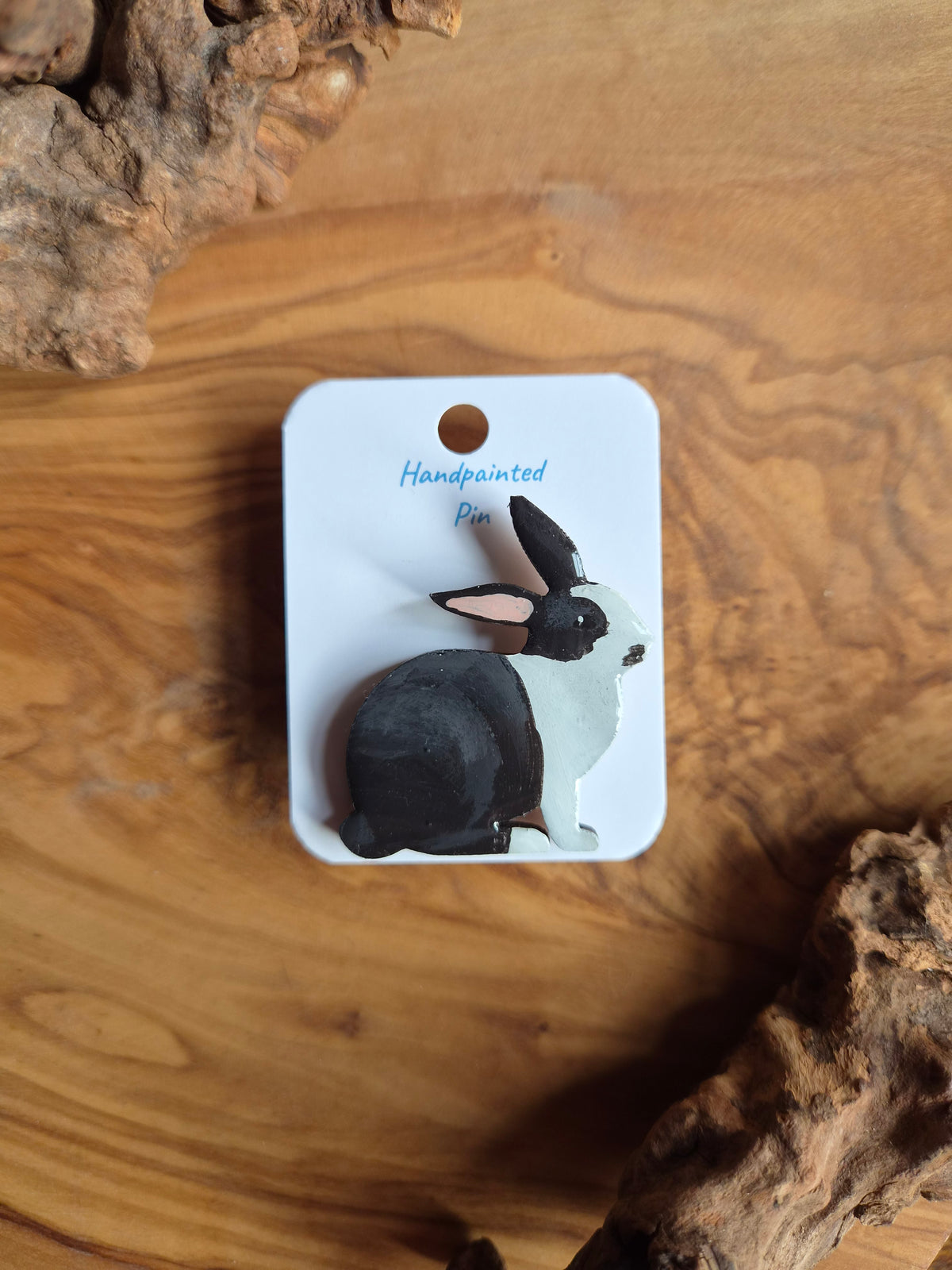 Hand-painted rabbit shaped wooden pin badge.  black and white colour