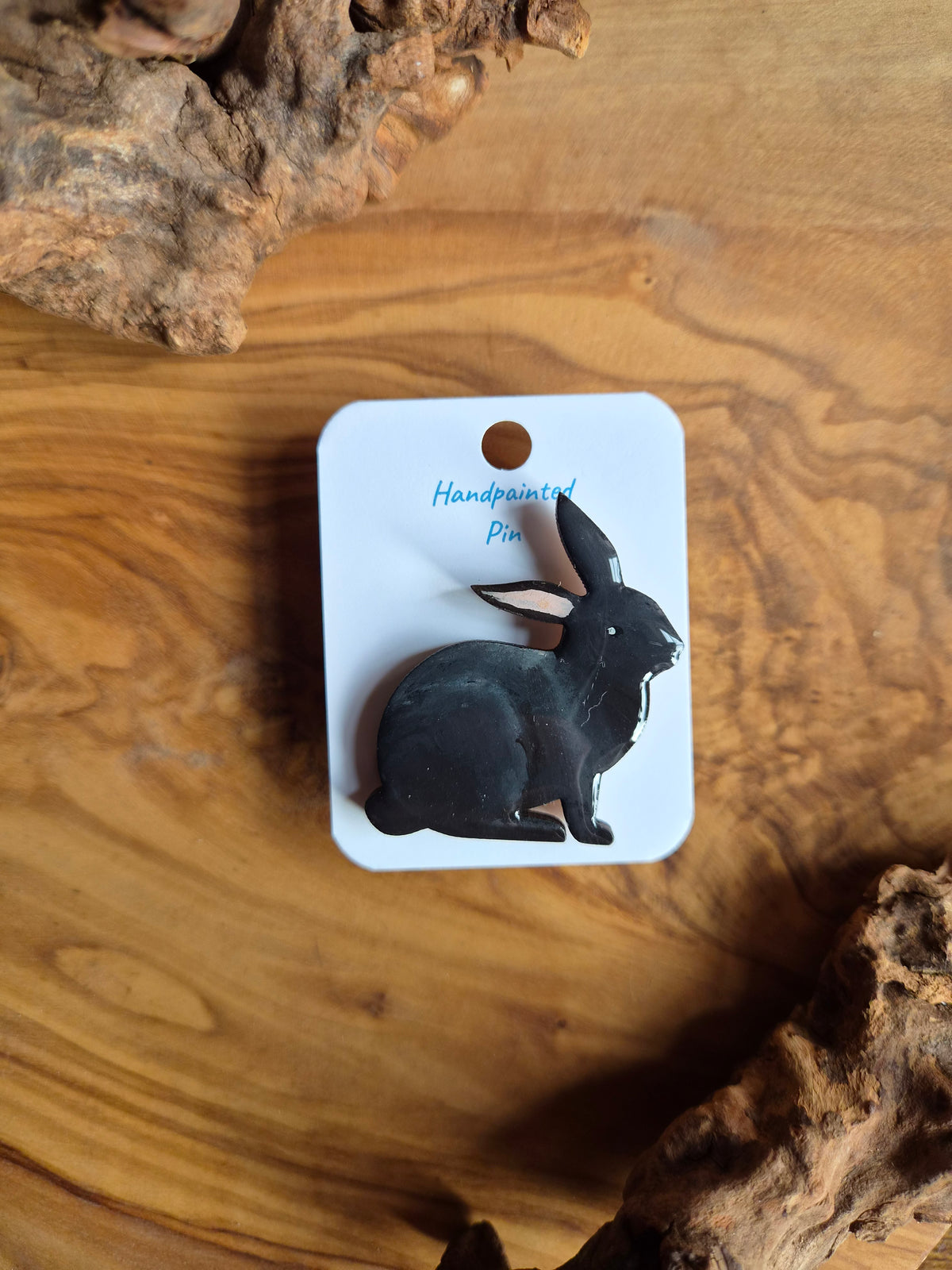 Hand-painted rabbit shaped wooden pin badge.  Black coloured rabbit